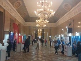 ludzie na tle sali w Pałacu Kultury i Nauki